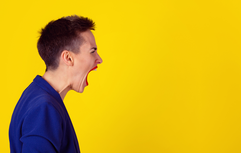 a side picture of a woman screaming to the top of her lungs in front of a yellow background