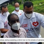 Bishop Joshua assists a blind man on the streets of Jamaica